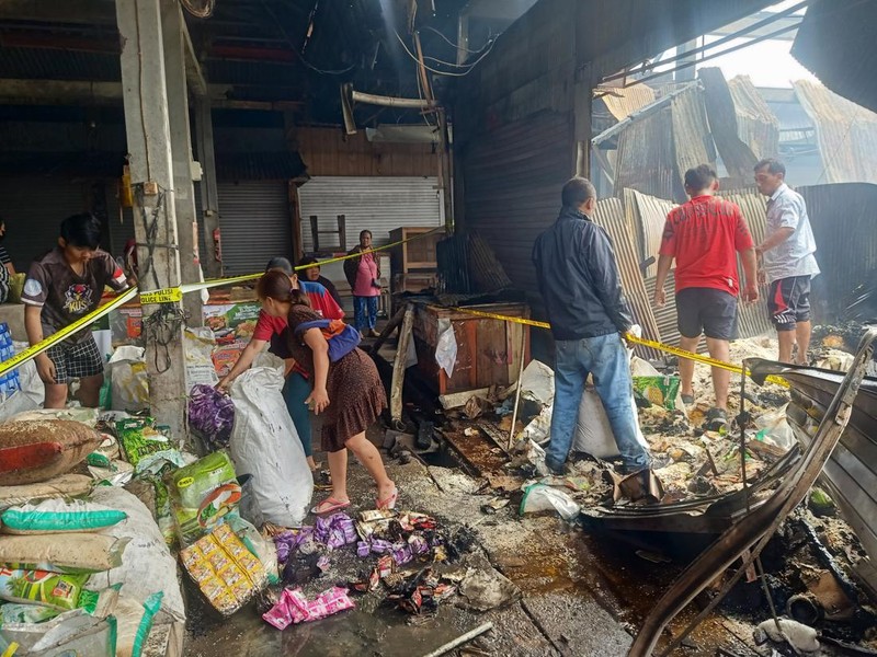 Para pedagang di Pasar Adat Lelateng memindahkan sisa barang dagangan yang tidak terbakar, Minggu (5/2/2023). (Foto: I Putu Adi Budiastrawan/detikBali)