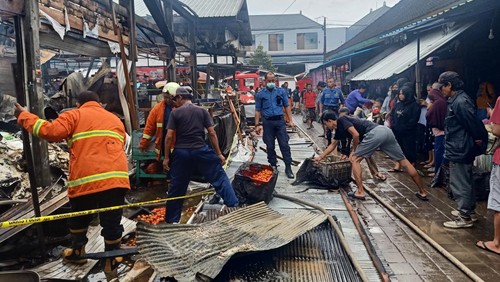 Petugas Damkar Kabupaten Jembrana kembali berupaya memadamkan api yang kembali muncul di bangunan Pasar Adat Lelateng, Minggu (5/2/2023) pagi.