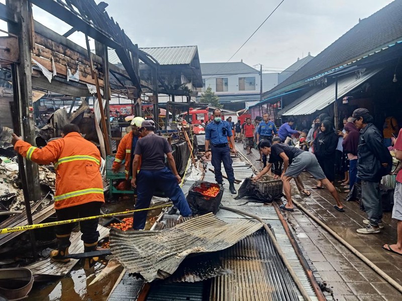 Petugas Damkar Kabupaten Jembrana kembali berupaya memadamkan api yang kembali muncul di bangunan Pasar Adat Lelateng, Minggu (5/2/2023) pagi.
