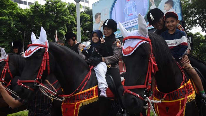Polisi Berkuda Hibur Warga Saat Hari Bebas Kendaraan Bermotor di Bundaran HI Sejumlah warga dan anak-anak berfoto dengan Polisi Berkuda dari Detasemen Turangga Direktorat Polisi Satwa Polri saat Hari Bebas Kendaraan Bermotor di kawasan Bundaran HI, Jakarta, Minggu (5/2/2023). Polisi berkuda selain ditugaskan untuk pengamanan simpatik juga untuk menghibur warga dan anak-anak saat Hari Bebas Kendaraan Bermotor serta memperkenalkan profesi tersebut kepada warga. ANTARA FOTO/Indrianto Eko Suwarso/tom.