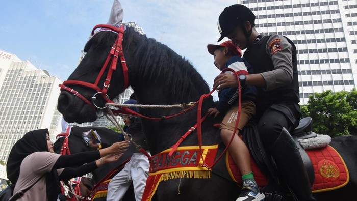 Polisi Berkuda Hibur Warga Saat Hari Bebas Kendaraan Bermotor di Bundaran HI Sejumlah warga dan anak-anak berfoto dengan Polisi Berkuda dari Detasemen Turangga Direktorat Polisi Satwa Polri saat Hari Bebas Kendaraan Bermotor di kawasan Bundaran HI, Jakarta, Minggu (5/2/2023). Polisi berkuda selain ditugaskan untuk pengamanan simpatik juga untuk menghibur warga dan anak-anak saat Hari Bebas Kendaraan Bermotor serta memperkenalkan profesi tersebut kepada warga. ANTARA FOTO/Indrianto Eko Suwarso/tom.