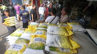 Pekerja menurunkan beras dari truk untuk dijual. Beras yang dijual seharga Rp45 ribu per lima kilogram.