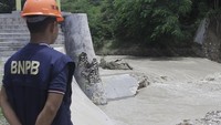 Seorang petugas Badan Penangulanggan Bencana (BNPB) memantau pintu air Bendungan Oesao yang jebol di Desa Pukdale, Kabupaten Kupang, NTT, Minggu (5/2/2023).