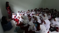 Meski sudah bisa kembali belajar di sekolah, para siswa masih duduk di lantai.
