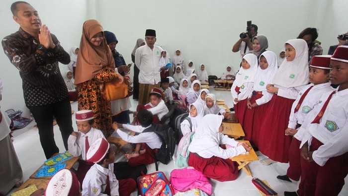 Akhirnya, Siswa SD/MI Cokroaminoto Kembali Belajar di Sekolah Wali Kota Surabaya Eri Cahyadi (kiri) menyapa sejumlah siswa SD/MI Cokroaminoto yang mengikuti pelajaran di salah satu ruangan di gedung sekolah YPI Cokroaminoto Jalan Petukangan Tengah, Surabaya, Jawa Timur, Senin (6/2/2023). Siswa SD/MI Cokroaminoto kembali belajar di lantai satu gedung sekolah yang telah direnovasi tersebut meski ruangan di lantai dua masih disegel oleh Pemkot Surabaya karena terkendala izin mendirikan bangunan (IMB). ANTARA FOTO/Didik Suhartono/foc.