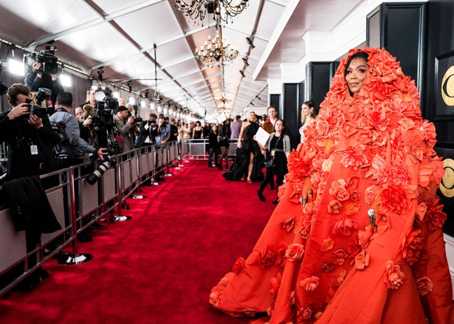 Lizzo membawa drama ke karpet merah Grammys 2023. Gaun jingga Dolce & Gabbana dengan coat penuh ornamen bunga tiga dimensi dan dipakai hingga menutupi kepala menjadi pilihannya. (Foto: John Shearer/Getty Images for The Recording Academy)