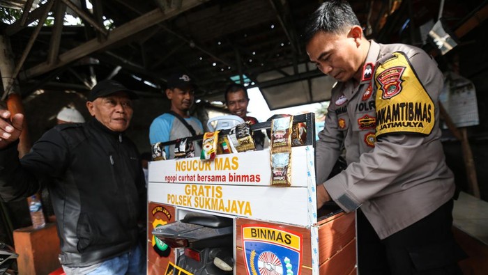 BINMAS BERBAGI KOPI GRATIS Polisi Aipda Mohadi berkeliling menggunakan kendaraan untuk berbincang dengan warga sambil memberikan kopi gratis di Cilodong, Depok, Jawa Barat, Senin (6/2/2023). Anggota Bhabinkamtibmas Polsek Sukmajaya tersebut secara swadaya membuat program NGUCUR MAS (Ngopi curhat bersama Binmas) dengan memberikan kopi gratis sambil berbincang dengan warga untuk memberikan rasa kenyamanan dan keamanan di wilayahnya. ANTARA FOTO/Asprilla Dwi Adha/nym.