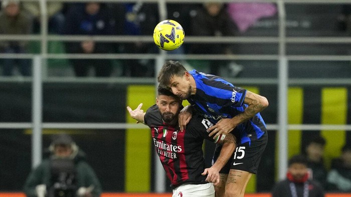 AC Milans Olivier Giroud, left, duels for the ball with Inter Milans Francesco Acerbi during the Serie A soccer match between Inter Milan and AC Milan at the San Siro Stadium, in Milan, Italy, Sunday, Feb. 5, 2023. (AP Photo/Antonio Calanni)
