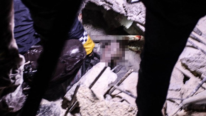 Gempa Juga Guncang Suriah, 42 Orang Tewas Tertimbun Reruntuhan Rescuers try to free a young boy from the rubble of a collapsed building follwoing an earthquake, in the Syrian border town of Azaz in the rebel-held north of the Aleppo province, early on February 6, 2023, - At least 42 have been reportedly killed in north Syria after a 7.8-magnitude earthquake that originated in Turkey and was felt across neighbouring countries. (Photo by Nayef Al-ABOUD / AFP) (Photo by NAYEF AL-ABOUD/AFP via Getty Images)