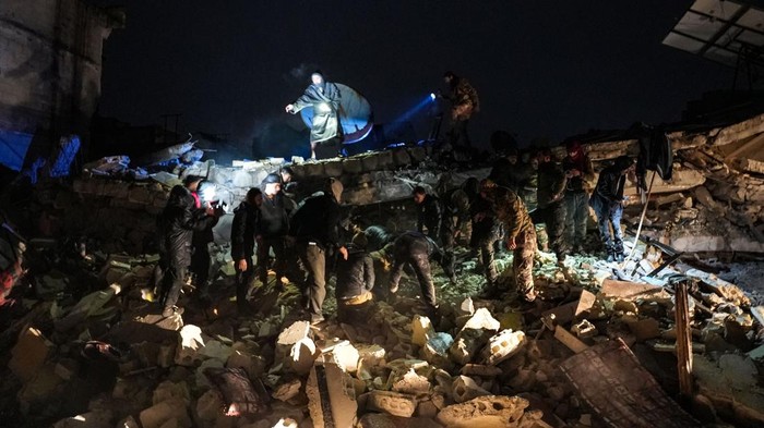 Civilians and fighters sift through the rubble of a collapsed building looking for victims and survivors following an earthquake in the town of Jandaris, in the countryside of Syria's northwestern city of Afrin in the rebel-held part of Aleppo province, early on February 6, 2023. - At least 42 have been reportedly killed in north Syria after a 7.8-magnitude earthquake that originated in Turkey and was felt across neighbouring countries. (Photo by Rami al SAYED / AFP) (Photo by RAMI AL SAYED/AFP via Getty Images)