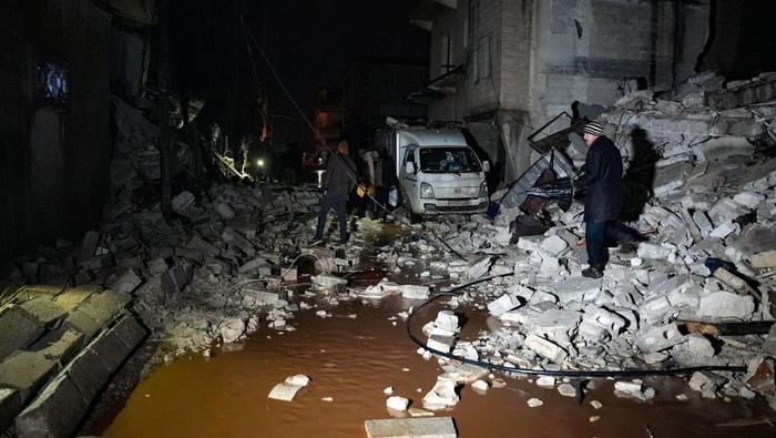 Residents walk through the rubble among collapsed buildings following an earthquake in the town of Jandaris, in the countryside of Syrias northwestern city of Afrin in the rebel-held part of Aleppo province, early on February 6, 2023. - At least 42 have been reportedly killed in north Syria after a 7.8-magnitude earthquake that originated in Turkey and was felt across neighbouring countries. (Photo by Rami al SAYED / AFP) (Photo by RAMI AL SAYED/AFP via Getty Images)