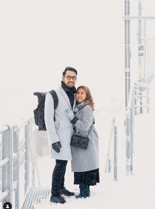 Kiky dan sang suami juga mengunjungi Swiss. Keduanya tampak berpose di tengah salju yang sedang turun di sana. Foto: Instagram/@kikysaputrii