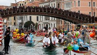 Warga Venesia mengambil bagian dalam parade topeng di Grand Canal selama karnaval Venesia, di Venesia, Italia, Minggu (5/2/2023).  