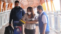 Petugas tampak memberikan penjelasan kepada pengguna skywalk yang baru mengetahui aturan ini.