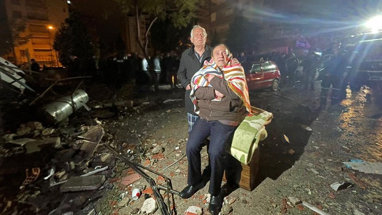 Momen Evakuasi Korban Gempa dari Reruntuhan Gedung di Turki ADANA, TURKIYE - FEBRUARY 6: Residents look towards the destroyed building in Yurt neighborhood of Cukurova district after the earthquake on February 6, 2023 in Adana, Turkiye. Search and rescue works continue in the areas. The 7.4 magnitude earthquake jolted Turkiyeâs southern province of Kahramanmaras early Monday, according to Turkiyeâs Disaster and Emergency Management Authority (AFAD). It was followed by a magnitude 6.4 quake that struck southeastern Gaziantep province. A third earthquake with a 6.5 magnitude also hit Gaziantep. (Photo by Omer Yildiz/Anadolu Agency via Getty Images)