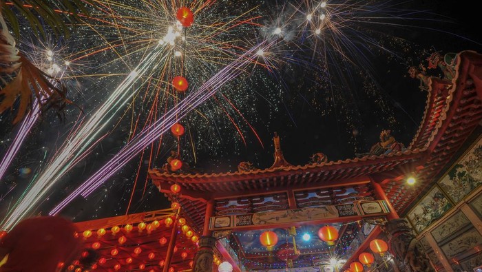 Sejumlah warga menyaksikan pesta kembang api saat puncak perayaan Cap Go Meh di Kelenteng Leng Chun Keng, Jambi, Minggu (5/2/2023). Puncak perayaan Cap Go Meh di daerah itu dimeriahkan dengan beberapa kegiatan hiburan dan pesta kembang api. ANTARA FOTO/Wahdi Septiawan/YU