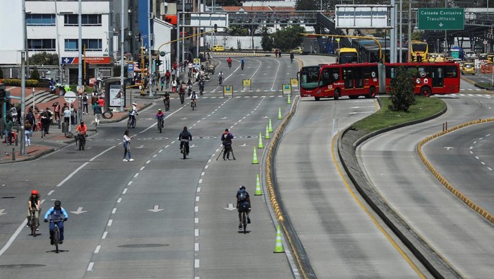 Transmilenio buses run on an avenue during 