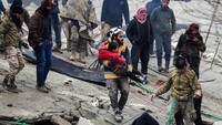 Tim penyelamat berhasil mengevakuasi seorang anak dari reruntuhan gedung di Kota Jandaris, Suriah. Reuters/Khalil Ashawi