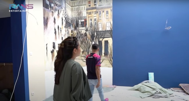 Raffi mengatakan jika restoran tersebut bergaya ala Eropa. Di dalamnya terdapat salah satu dinding yang dilukis dengan gambar-gambar gedung dan orang-orang berlalu lalang, seperti suasana di Eropa. Foto: YouTube/Rans Entertainment