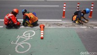 Para pekerja melakukan perawatan stick cone jalur sepeda di Jl Penjernihan I, Tanah Abang, Jakarta, Senin (6/2/2023).