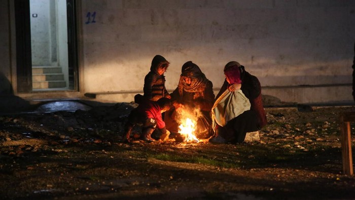 Usai Diguncang Gempa, Warga Turki Terjebak Udara Dingin Mencekam ALEPPO, SYRIA - FEBRUARY 6: People heat themselves outside of destroyed settlements in Aleppo, Syria on February 6, 2023. Search and rescue works continue in the areas. The 7.4 magnitude earthquake jolted Turkiyeâs southern province of Kahramanmaras early Monday, according to Turkiyeâs Disaster and Emergency Management Authority (AFAD). It was followed by a magnitude 6.4 quake that struck southeastern Gaziantep province. A third earthquake with a 6.5 magnitude also hit Gaziantep. (Photo by Mustafa Bathis/Anadolu Agency via Getty Images)