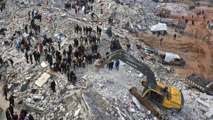 Civil defense workers and residents search through the rubble of collapsed buildings in the town of Harem near the Turkish border, Idlib province, Syria, Monday, Feb. 6, 2023. A powerful earthquake has caused significant damage in southeast Turkey and Syria and many casualties are feared. Damage was reported across several Turkish provinces, and rescue teams were being sent from around the country. (AP Photo/Ghaith Alsayed)