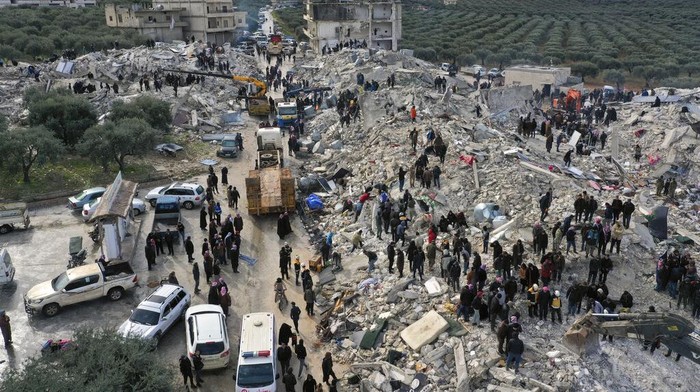 Civil defense workers and residents search through the rubble of collapsed buildings in the town of Harem near the Turkish border, Idlib province, Syria, Monday, Feb. 6, 2023. A powerful earthquake has caused significant damage in southeast Turkey and Syria and many casualties are feared. Damage was reported across several Turkish provinces, and rescue teams were being sent from around the country. (AP Photo/Ghaith Alsayed)