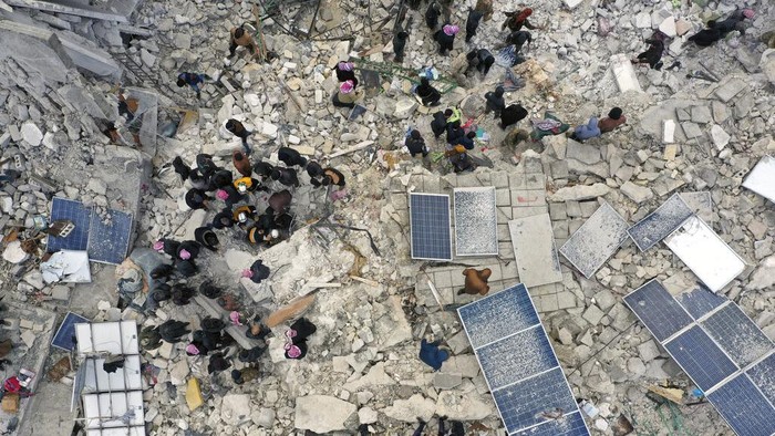 Civil defense workers and residents search through the rubble of collapsed buildings in the town of Harem near the Turkish border, Idlib province, Syria, Monday, Feb. 6, 2023. A powerful earthquake has caused significant damage in southeast Turkey and Syria and many casualties are feared. Damage was reported across several Turkish provinces, and rescue teams were being sent from around the country. (AP Photo/Ghaith Alsayed)