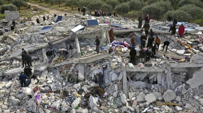 Pantauan Udara Pencarian Korban Gempa di Suriah Civil defense workers and residents search through the rubble of collapsed buildings in the town of Harem near the Turkish border, Idlib province, Syria, Monday, Feb. 6, 2023. A powerful earthquake has caused significant damage in southeast Turkey and Syria and many casualties are feared. Damage was reported across several Turkish provinces, and rescue teams were being sent from around the country. (AP Photo/Ghaith Alsayed)