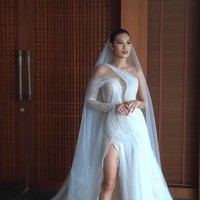 Patricia Gouw mengenakan gaun putih detail shoulder asimetris yang melengkung elegan hingga membungkus bagian bodice. Gaun yang dilengkapi veil tersebut juga memiliki bukaan pada bagian belakang yang menonjolkan aura seksi Patricia sebagai model. Sementara itu material lace memberi sentuhan akhir yang romantis.  Foto: Instagram