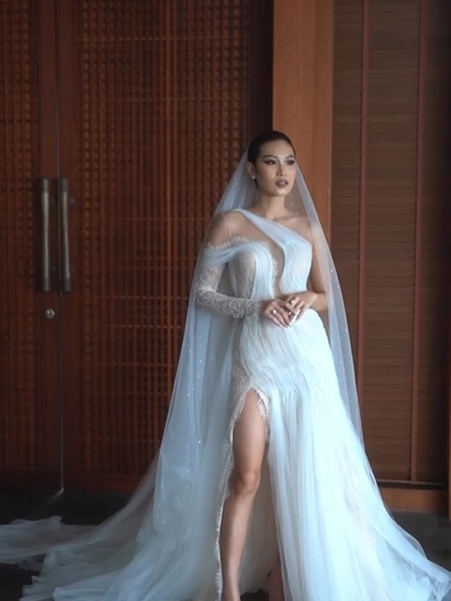 Patricia Gouw mengenakan gaun putih detail shoulder asimetris yang melengkung elegan hingga membungkus bagian bodice. Gaun yang dilengkapi veil tersebut juga memiliki bukaan pada bagian belakang yang menonjolkan aura seksi Patricia sebagai model. Sementara itu material lace memberi sentuhan akhir yang romantis.  Foto: Instagram