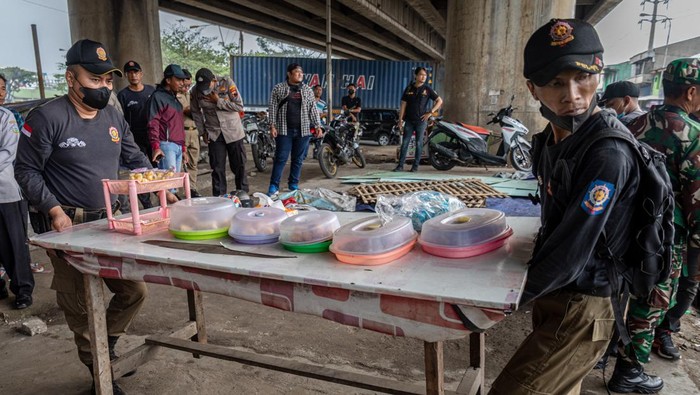 Petugas Satpol PP Kota Semarang mengangkut lapak pedagang kaki lima saat menertibkan bangunan liar di bawah jembatan layang Pelabuhan Tanjung Mas Semarang, Jawa Tengah, Selasa (7/2/2023). Sepuluh dari sekitar seratus bangunan liar seperti pedagang kaki lima, hunian bedeng, serta 29 tempat karaoke tak berizin yang berada di area itu dibongkar Satpol PP Kota Semarang yang sisanya akan dibongkar secara mandiri oleh pemilknya sebagai upaya menata kawasan Kota Semarang agar lebih rapi dengan rencana pembangunan taman oleh Pemkot Semarang senilai Rp10 miliar di kawasan tersebut.