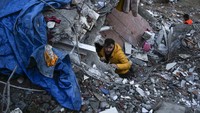 Tim SAR harus menembus celah reruntuhan bangunan untuk mengevakuasi korban gempa di Adana, Turki. AP Photo/Khalil Hamra.
