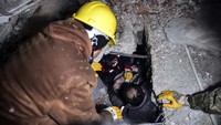 Tim SAR berhasil menyelamatkan seorang warga dari reruntuhan bangunan di Elbistan, Kahramanmaras, Turki. Ismail Coskun/IHA via AP.
