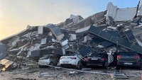 Pemandangan kendaraan di bawah bangunan yang runtuh setelah gempa bumi di Hatay, Turki. REUTERS/Huseyin Hayatsever  
