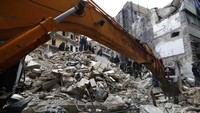 Petugas Pertahanan Sipil Suriah dan pasukan keamanan mencari korban di antara puing-puing bangunan yang runtuh, di Aleppo, Suriah, Senin (6/2/2023). AP/Omar Sanadiki  