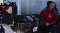 Petugas pemadam kebakaran Spanyol memuat koper ke troli bandara di bandara internasional Barajas dalam perjalanan untuk membantu misi penyelamatan di Turki. AP/Paul White  