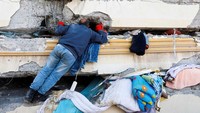 Tim SAR juga harus melewati celah reruntuhan bangunan untuk mengevakuasi korban gempa di Turki. Reuters/Suhaib Salem.