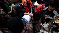 Tim SAR berhasil menyelamatkan seorang warga dari reruntuhan bangunan di Hatay, Turki. Reuters/Guglielmo Mangiapane.