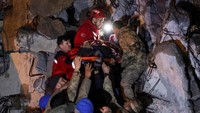 Tim SAR berhasil menyelamatkan seorang warga dari reruntuhan bangunan di Iskenderun, Turki. Reuters/Umit Bektas.