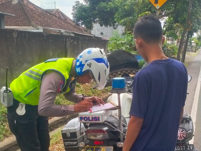 Petugas kepolisian Polres Jembrana saat melakukan teguran terhadap pengendara sepeda motor yang melanggar aturan berlalulintas, Selasa (7/2/2023).