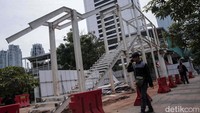 Sejumlah warga berjalan di dekat proyek revitalisasi Halte Dukuh Atas 1, Jakarta Selatan.