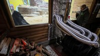 Tony, gorila berusia 48 tahun, duduk di samping tungku kayu yang memanaskan kandangnya, di tengah serangan Rusia terhadap Ukraina, di kebun binatang di Kiev, Ukraina, Selasa (31/1/2023).  