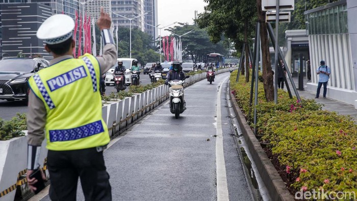 Dihadang Polisi, Pemotor Putar Balik di Jalur Sepeda Polisi melakukan sterilisasi jalur sepeda di kawasan Sudirman, Jakarta, Rabu (8/2/2023). Pemotor yang nekat masuk dipaksa putar balik.