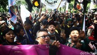 Massa memakai rompi ojol berwarna hijau terus menyampaikan tuntutannya.  