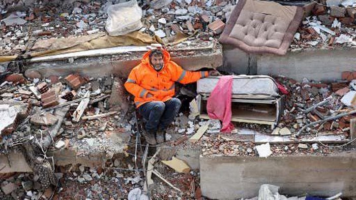 Duka Ayah yang Pegang Tangan Putrinya di Reruntuhan Bangunan Mesut Hancer holds the hand of his 15-year-old daughter Irmak, who died in the earthquake in Kahramanmaras, close to the quake's epicentre, the day after a 7.8-magnitude earthquake struck the country's southeast, on February 7, 2023. - Rescuers in Turkey and Syria braved frigid weather, aftershocks and collapsing buildings, as they dug for survivors buried by an earthquake that killed more than 5,000 people. Some of the heaviest devastation occurred near the quake's epicentre between Kahramanmaras and Gaziantep, a city of two million where entire blocks now lie in ruins under gathering snow. (Photo by Adem ALTAN / AFP)