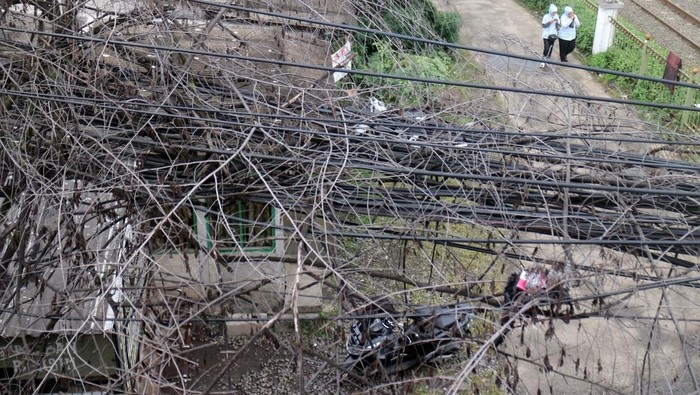 Warga menjemur pakaian dengan latar depn kabel telekomunikasi yang semrawut di Cibinong, Kabupaten Bogor, Jawa Barat, Selasa (7/2/2023). Kesemrawutan penataan instalasi kabel listrik dan telekomunikasi tersebut menggangu keindahan tata ruang kota. ANTARA FOTO/Yulius Satria Wijaya/aww.