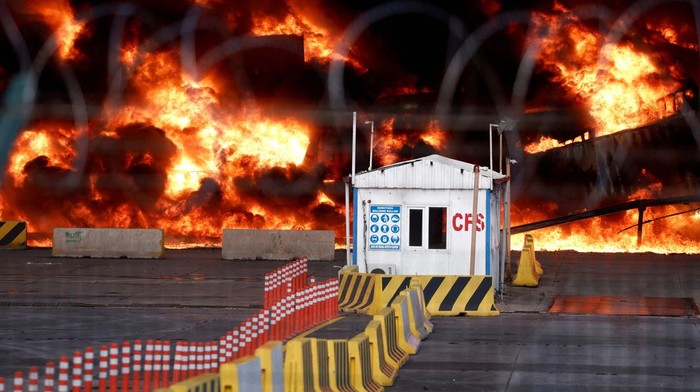 Smoke rises from burning containers at the port in the earthquake-stricken town of Iskenderun, Turkey, February 7, 2023. REUTERS/Benoit Tessier