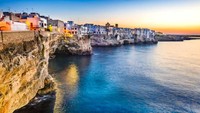 Tebing-tebing ini juga menjadi tuan rumah dari acara Red Bull Cliff Diving Polignano e Mare yang legendaris di setiap musim panas. Para penyelam profesional berkumpul di sana untuk melakukan aksi terjun ke lautan. Getty Images/iStockphoto/emicristea