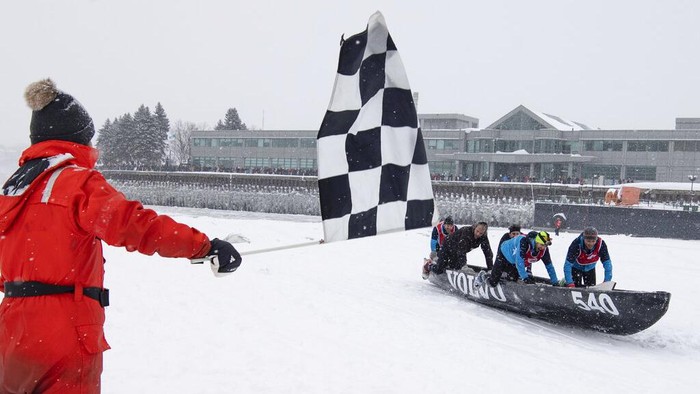 Some of the 50 teams take the start of the Quebec Winter Carnival ice canoe race across the St. Lawrence River, Sunday, Feb. 5, 2023, in Quebec City. (Jacques Boissinot/The Canadian Press via AP)